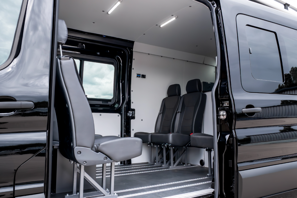 Crewcab conversion by SMUK showing rear and forward facing rows of seats in the back of a van